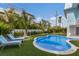 Private backyard oasis with a freeform pool, putting green, and lounge chairs at 118 Mangrove Ave, Anna Maria, FL 34216