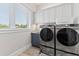 Laundry room with modern washer and dryer, and built-in cabinets at 118 Mangrove Ave, Anna Maria, FL 34216