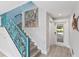 Modern staircase with unique teal railing and ocean-themed art at 118 Mangrove Ave, Anna Maria, FL 34216