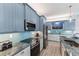 Kitchen with stainless steel appliances and blue cabinetry at 118 Mangrove Ave, Anna Maria, FL 34216