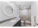 Bathroom with a large vanity, walk-in shower and round mirror at 118 Mangrove Ave, Anna Maria, FL 34216