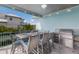 Covered patio features a dining table and built-in grill for outdoor entertaining at 118 Mangrove Ave, Anna Maria, FL 34216