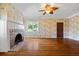 Living room with hardwood floors, brick fireplace, and decorative wallpaper at 7754 Westmoreland Dr, Sarasota, FL 34243