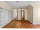 Bedroom with hardwood floors, built-in shelving, and access to other rooms at 7754 Westmoreland Dr, Sarasota, FL 34243