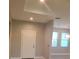 View of the home's light-filled entryway with a white door and sleek design, complemented by a glimpse into the kitchen at 13126 Marathon Blvd, Port Charlotte, FL 33981