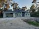 Newly constructed single-Gathering home with a two-car garage and well-lit windows, set amidst a serene, wooded landscape at 13126 Marathon Blvd, Port Charlotte, FL 33981