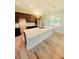 Bright eat-in kitchen featuring a large marble island, dark cabinetry, hardwood floors, and stylish light fixtures at 13126 Marathon Blvd, Port Charlotte, FL 33981