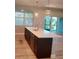 Modern kitchen island with quartz countertops, wooden cabinets, pendant lights, and stainless steel appliances at 13126 Marathon Blvd, Port Charlotte, FL 33981