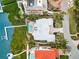 Aerial view of waterfront home with a pool, dock, and manicured backyard, perfect for relaxation at 757 Hideaway Bay Dr, Longboat Key, FL 34228