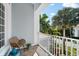 Cozy balcony with a chair and side table offering serene views of lush greenery and palm trees at 757 Hideaway Bay Dr, Longboat Key, FL 34228