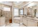 Luxurious bathroom with a soaking tub, walk-in shower, and elegant vanity with granite countertop at 757 Hideaway Bay Dr, Longboat Key, FL 34228