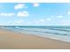 Scenic beach view with gentle waves under a bright blue sky, perfect for relaxing strolls and enjoying the ocean breeze at 757 Hideaway Bay Dr, Longboat Key, FL 34228