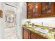 Butler pantry with sink, granite countertop, custom wood cabinetry, and convenient access at 757 Hideaway Bay Dr, Longboat Key, FL 34228