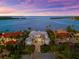 Stunning waterfront home with lush landscaping, brick driveway, and beautiful views of the serene bay at 757 Hideaway Bay Dr, Longboat Key, FL 34228