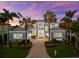 Stunning multi-story home with lush landscaping, symmetrical dormers, and brick paver driveway at 757 Hideaway Bay Dr, Longboat Key, FL 34228
