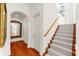 Bright hallway featuring hardwood floors, white walls, and a carpeted staircase at 757 Hideaway Bay Dr, Longboat Key, FL 34228