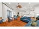Spacious living room with a modern kitchen, hardwood floors, blue furniture, and white cabinets at 757 Hideaway Bay Dr, Longboat Key, FL 34228