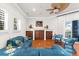 Bright living room featuring a large blue sectional sofa, ceiling fan, and dark wood cabinet at 757 Hideaway Bay Dr, Longboat Key, FL 34228