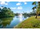 Scenic pond featuring a fountain and grassy shore, surrounded by lush green foliage at 757 Hideaway Bay Dr, Longboat Key, FL 34228