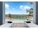 Relaxing poolside view with comfortable lounge chairs, lush greenery, and a sparkling bay in the distance at 757 Hideaway Bay Dr, Longboat Key, FL 34228