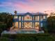Elegant multi-story home with balconies, pool, and spa is surrounded by lush tropical landscaping at 757 Hideaway Bay Dr, Longboat Key, FL 34228