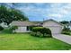 Single-story house with a light-colored exterior, two-car garage, and well-maintained lawn at 9390 Gulfstream Blvd, Englewood, FL 34224