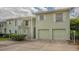 Light green duplex with two-car garage and exterior stairs at 5082 Oak Run Dr, Sarasota, FL 34243