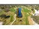 Aerial view of a lush green golf course with a pond at 5082 Oak Run Dr, Sarasota, FL 34243