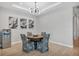 Bright dining area with a round table and four chairs, hardwood floors and modern light fixture at 10279 Morning Mist Ln, Sarasota, FL 34241