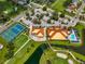 Aerial view showing tennis courts, clubhouse, and pool at 4726 Sand Trap Street E Cir, Bradenton, FL 34203
