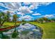 Serene lakefront view with lush landscaping and homes at 4726 Sand Trap Street E Cir, Bradenton, FL 34203