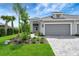 Two-car garage and walkway of a new home with landscaping at 2638 Light Sky Ln, Bradenton, FL 34211