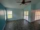 Bright bedroom with teal walls, dark gray tile floors, and white plantation shutters at 5009 Sturbridge Ct, Sarasota, FL 34238