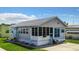 Charming single-Gathering home features a metal roof, screened-in porch, and light gray siding with blue shutters at 3333 26Th E Ave # 1099, Bradenton, FL 34208