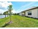 The manicured backyard with sloping lawn and pond offers a tranquil outdoor living space at 305 Potenza Loop, Nokomis, FL 34275