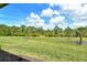 Landscaped backyard is complete with a lush lawn, mature trees, and a tranquil pond at 305 Potenza Loop, Nokomis, FL 34275
