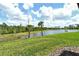 Waterfront backyard features a grassy lawn that slopes down to a tranquil pond at 305 Potenza Loop, Nokomis, FL 34275