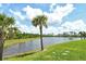 Backyard features a scenic pond and mature palm trees that enhance the property's appeal at 305 Potenza Loop, Nokomis, FL 34275