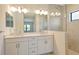 Modern bathroom with double vanity, large mirror, elegant lighting, and glass-enclosed shower at 305 Potenza Loop, Nokomis, FL 34275