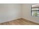 Bright bedroom with wood-look flooring, large window, neutral wall color, and ample space at 305 Potenza Loop, Nokomis, FL 34275