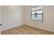 The bedroom has wood-look floors, a bright window with blinds, and crisp white paint at 305 Potenza Loop, Nokomis, FL 34275