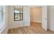 Bright bedroom featuring wood-look floors and an open doorway to another room at 305 Potenza Loop, Nokomis, FL 34275