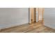 Bright bedroom features wood-look floors, fresh white trim, and an open closet with a door at 305 Potenza Loop, Nokomis, FL 34275