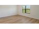 Bright, light-filled bedroom featuring wood-look flooring and a large window at 305 Potenza Loop, Nokomis, FL 34275
