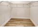 Walk-in closet with wire shelving, wood-look flooring, and ample storage space at 305 Potenza Loop, Nokomis, FL 34275