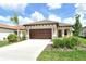 Charming single-story home featuring a tile roof, two-car garage, and lush landscaping at 305 Potenza Loop, Nokomis, FL 34275