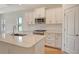 Well-appointed kitchen with stainless appliances, white cabinets, and quartz countertops at 305 Potenza Loop, Nokomis, FL 34275