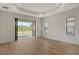 Bright living room with wood-look floors, recessed lighting, and sliding glass doors to patio at 305 Potenza Loop, Nokomis, FL 34275
