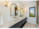 Modern bathroom with double vanity, gold fixtures, and large mirrors at 111 Gull Dr, Anna Maria, FL 34216