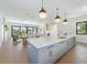 Open kitchen with gray island, white cabinets, and built-in microwave at 111 Gull Dr, Anna Maria, FL 34216